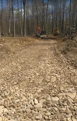Finished gravel driveway and access road with excavators on site, graded by Landmark Enterprises in Chautauqua County, NY
