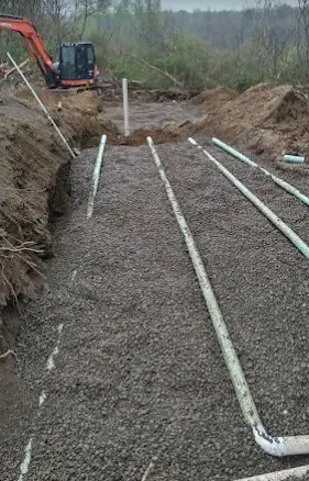 Septic drain field in gravel with an excavator on site during a Landmark Enterprises septic system install, Dewittville, NY